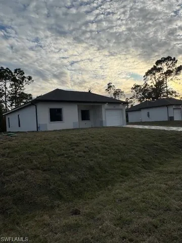 Ranch-style house with a yard and a garage