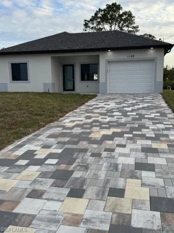 View of front of home featuring a garage and a front yard