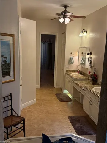 Bedroom with ceiling fan and light tile patterned flooring