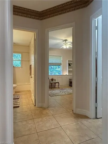 Tiled office space with ceiling fan and ornamental molding