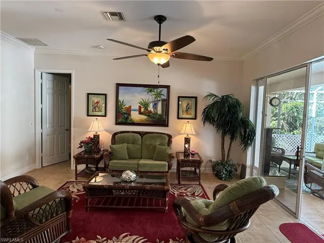 Tiled living room featuring ceiling fan and crown molding