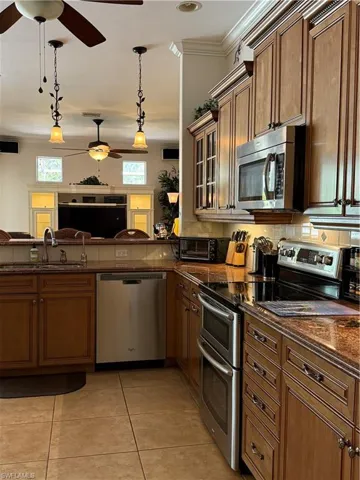 Kitchen with stainless steel fridge with ice dispenser, sink, and hanging light fixtures