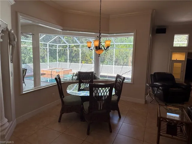 Dining room with tile patterned floors and an inviting chandelier