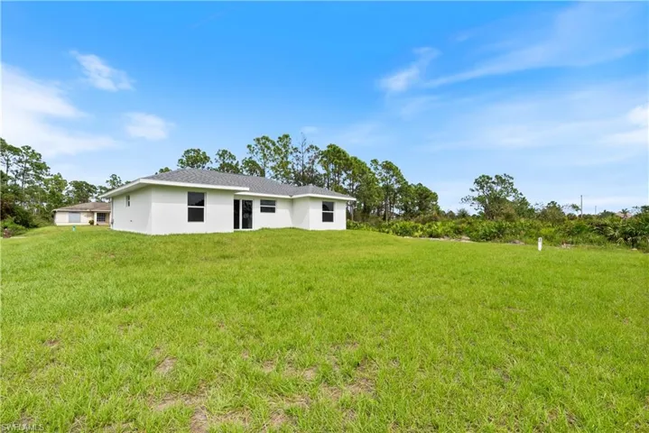 Rear view of house featuring a yard
