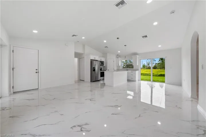 Unfurnished living room with lofted ceiling