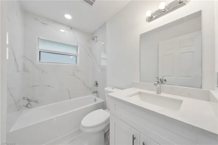 Full bathroom featuring vanity, toilet, and tiled shower / bath
