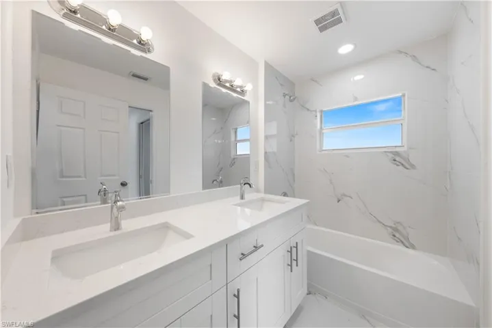 Bathroom with vanity and tiled shower / bath