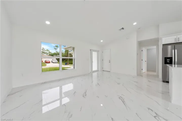 Unfurnished living room featuring lofted ceiling