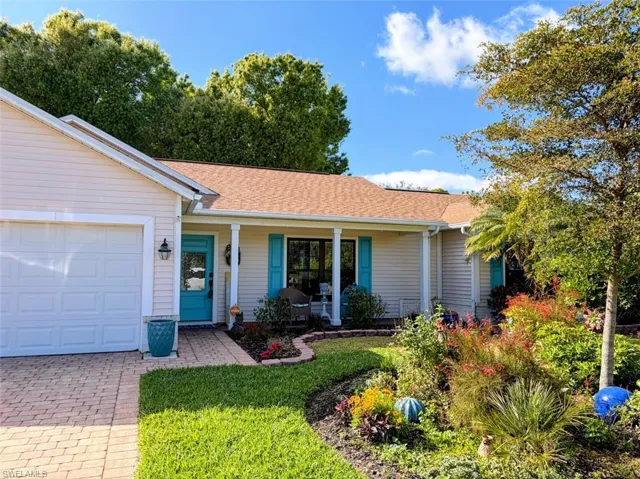Ranch-style house with a porch, roof with shingles, a front yard, and driveway