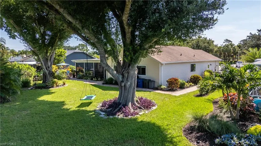 Rear view of property featuring a yard and a sunroom