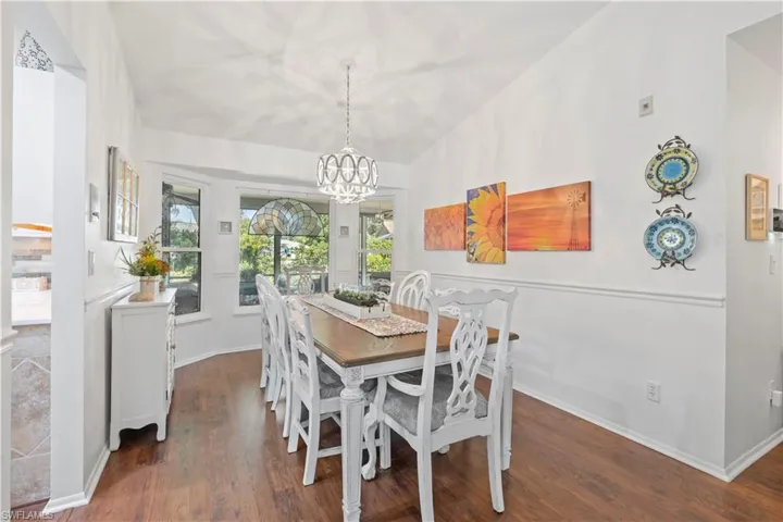 Dining space with a chandelier, wood finished floors, and lofted ceiling