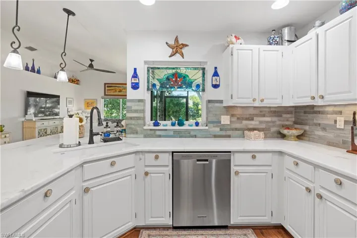 Kitchen featuring dishwasher, a ceiling fan, backsplash, white cabinetry, and recessed lighting