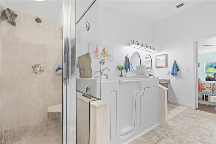 Full bathroom featuring a tile shower and vanity