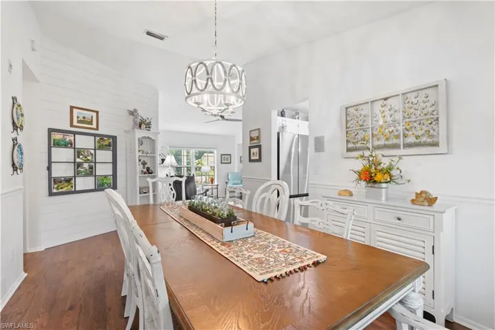 Dining room with a chandelier and dark wood-type flooring