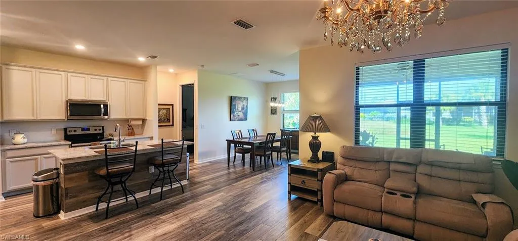 Living area featuring dark wood finished floors, recessed lighting, and a chandelier