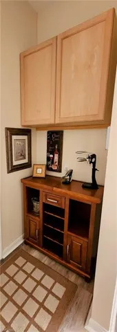 Bar with light brown cabinets and light wood finished floors