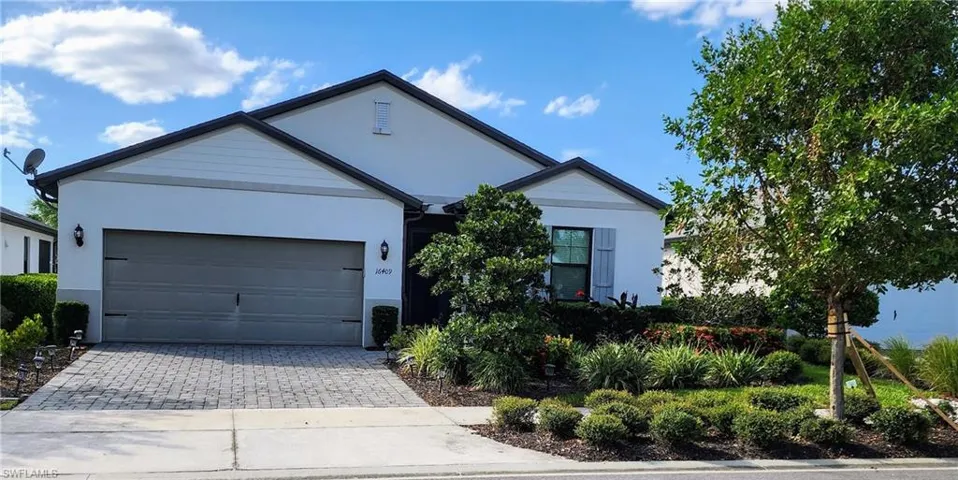 View of front of house featuring decorative driveway, stucco siding, and an attached garage