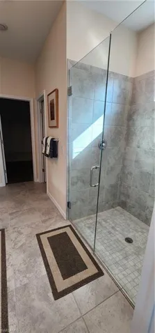 Bathroom with a stall shower and baseboards