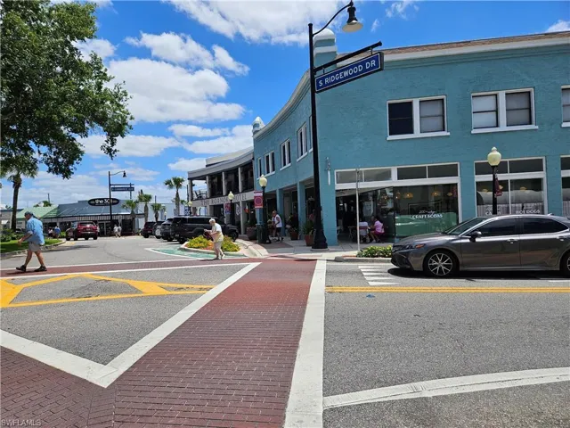View of asphalt street with curbs, street lights, and sidewalks