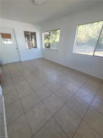 Empty room featuring light tile patterned flooring and a textured ceiling