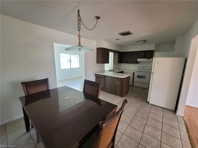 Dining space with light tile patterned flooring and a textured ceiling
