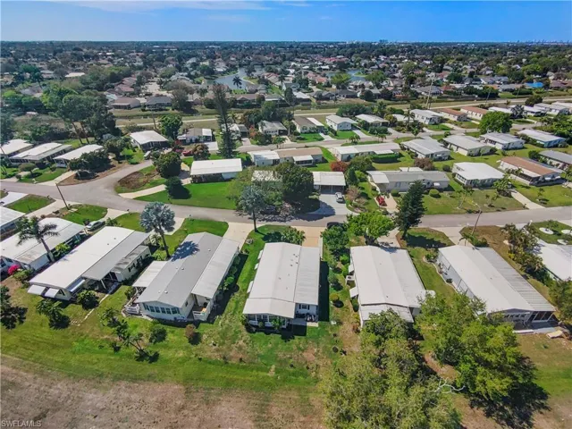 Aerial perspective showcasing a residential community with numerous single-story homes and mature trees