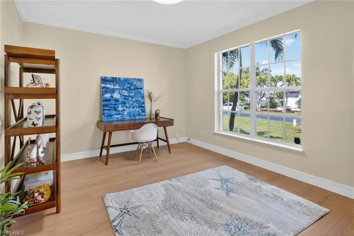 Office space featuring light wood-type flooring and crown molding
