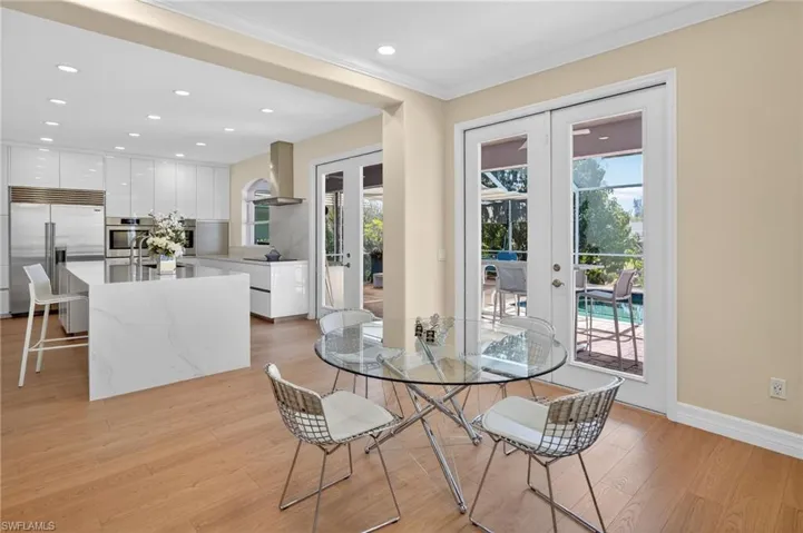 Dining room featuring french doors, light wood-style flooring, recessed lighting, and ornamental molding