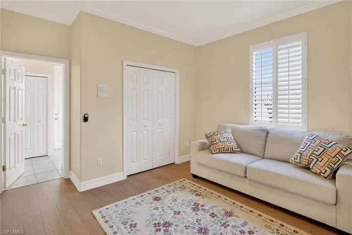 Living area with light wood-type flooring and ornamental molding