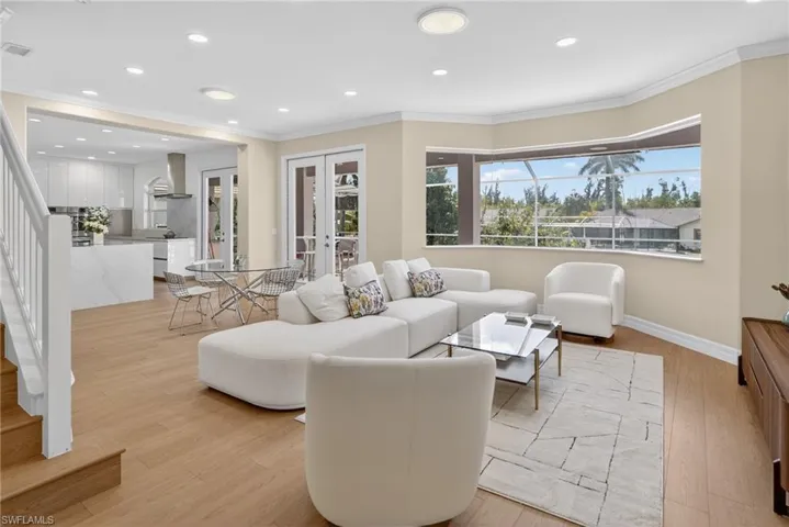Living area with french doors, recessed lighting, light wood-type flooring, and crown molding