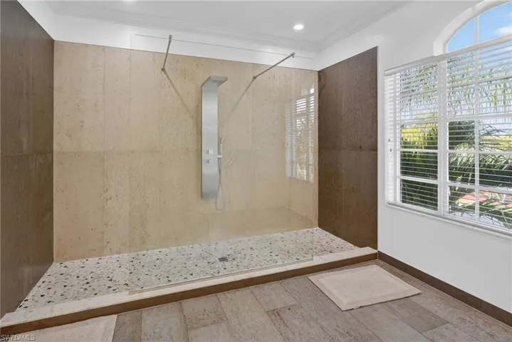 Bathroom with a walk in shower and ornamental molding
