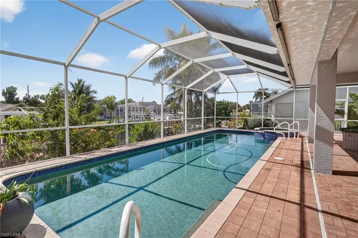 Integrated pool / spa featuring a lanai, a sunroom, and a patio