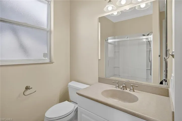 Bathroom with vanity, an enclosed shower, and crown molding
