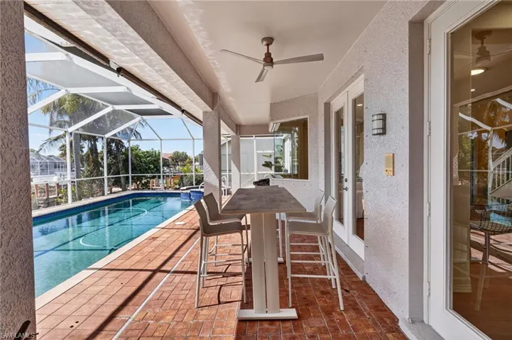 Swimming pool featuring a patio area, a lanai, a sunroom, and french doors