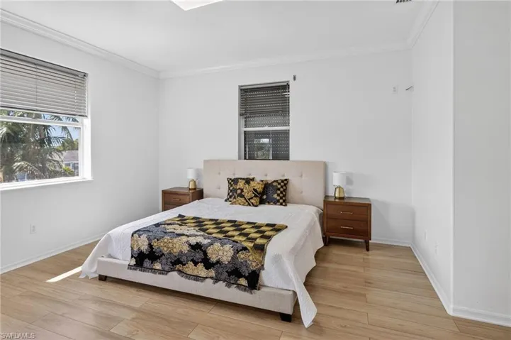 Bedroom featuring wood finished floors and ornamental molding