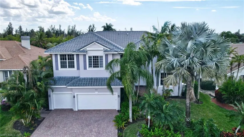 View of front of house featuring a tile roof, an attached garage, and stucco siding