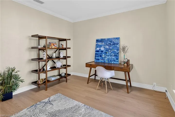 Office with crown molding and light wood-style flooring