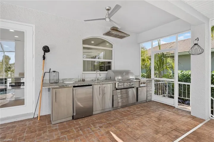 View of patio featuring a sunroom, area for grilling, and a ceiling fan