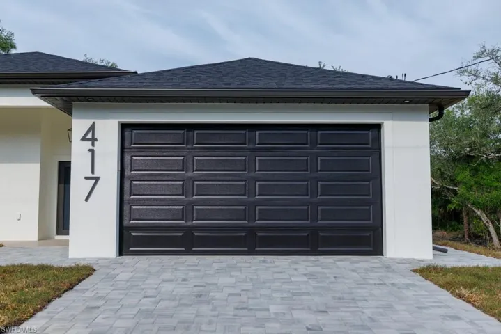 Garage featuring decorative driveway