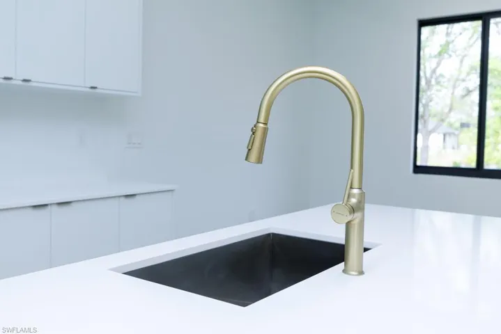 Details featuring white cabinetry, light countertops, and a sink