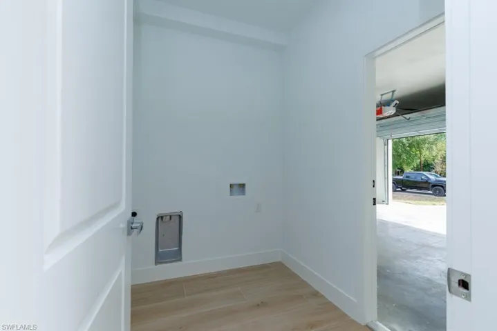 Clothes washing area featuring hookup for a washing machine, baseboards, light wood finished floors, ceiling fan, and laundry area