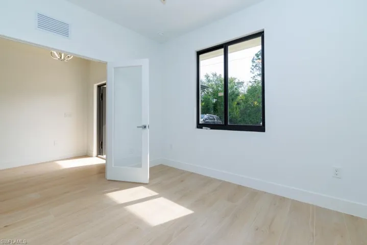 Spare room with baseboards, visible vents, and wood finished floors