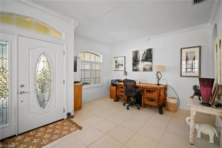 Entryway featuring ornamental molding and light tile patterned floors