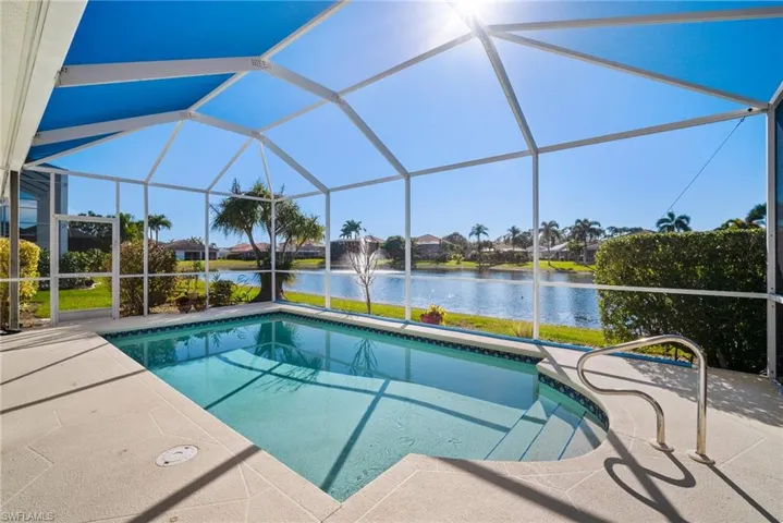 View of pool featuring a water view and glass enclosure