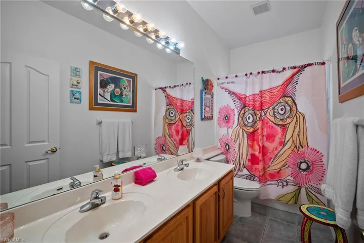 Bathroom featuring vanity, toilet, and tile patterned flooring