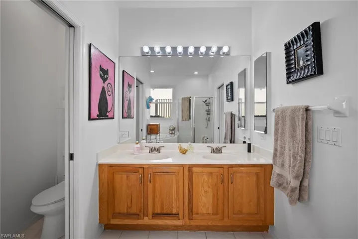 Bathroom with tile patterned flooring, toilet, vanity, and walk in shower