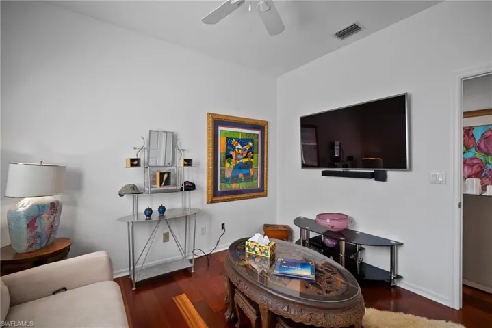 Living room featuring dark hardwood / wood-style floors and ceiling fan