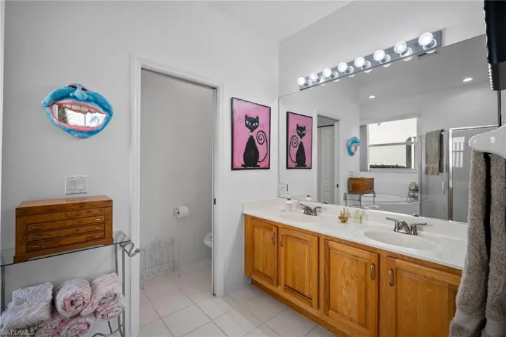Full bathroom featuring tile patterned flooring, vanity, independent shower and bath, and toilet