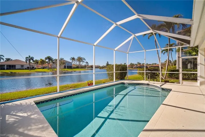 View of swimming pool featuring a water view, a lanai, and a patio area