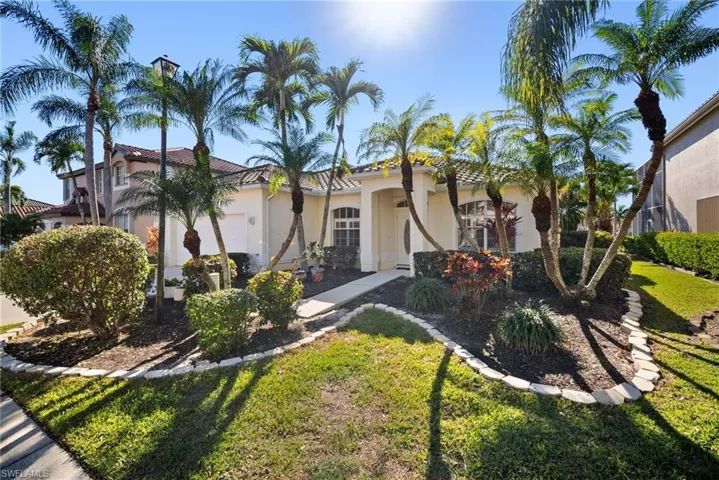 Mediterranean / spanish home featuring a garage and a front lawn